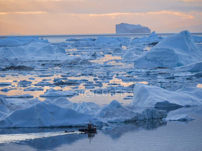 Лодка на Илулиссат Айсфьорд также называлась Кангия или Илулиссат Кангерлуа в заливе Диско. Ледяной фьорд включен в список Всемирного наследия ЮНЕСКО. Америка, Северная Америка, Гренландия, Дания — стоковое фото