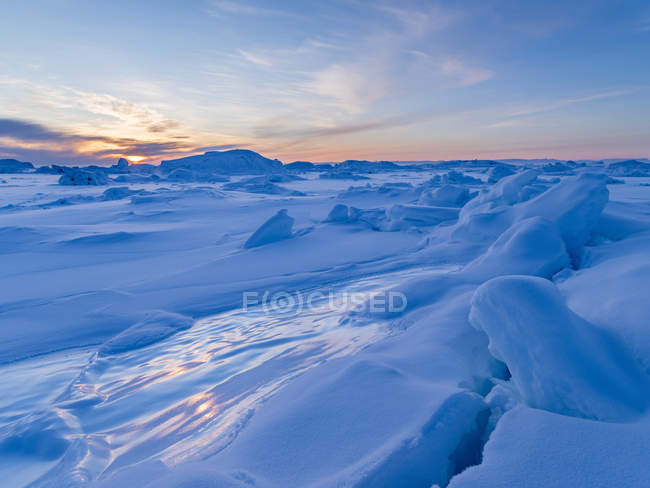 La orilla de la bahía congelada de Disko. Town Ilulissat at the shore of Disko Bay in West Greenland. El fiordo de hielo cercano está catalogado como patrimonio mundial de la UNESCO. América, América del Norte, Groenlandia, Dinamarca - foto de stock