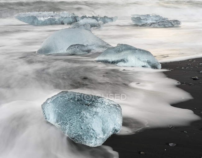 Icebergs sur la plage volcanique noire. Plage de l'Atlantique Nord près de la lagune glaciaire Joekulsarlon et du glacier Breithamerkurjoekull dans le Vatnajoekull NP.europe, Europe du Nord, iceland, Février — Photo de stock