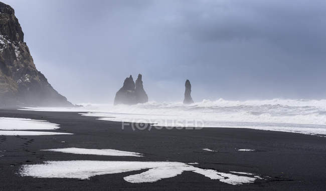 La costa dell'Atlantico settentrionale vicino a Vik y Myrdal durante l'inverno. Spiaggia vulcanica nera Reynisfjara con il mare stack Reynisdrangar. Europa, Nord Europa, Scandinavia, Islanda, febbraio — Foto stock
