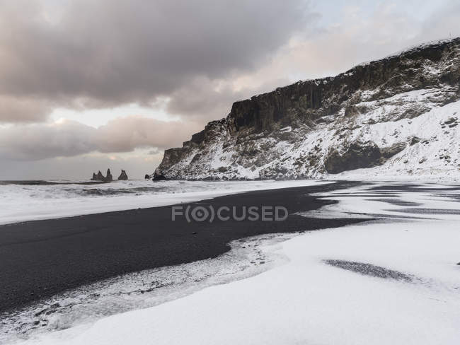 La costa dell'Atlantico settentrionale vicino a Vik y Myrdal durante l'inverno. Spiaggia vulcanica nera con le pile di mare Reynisdrangar. Europa, Nord Europa, Scandinavia, Islanda, febbraio — Foto stock