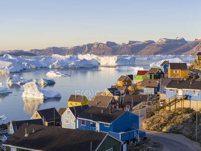 Vista del fiordo pieno di iceberg verso la penisola di Nuussuaq (Nugssuaq) durante il sole di mezzanotte. La città di Uummannaq nel nord della Groenlandia occidentale, situata su un'isola nel sistema del fiordo di Uummannaq. America, Nord America, Groenlandia — Foto stock