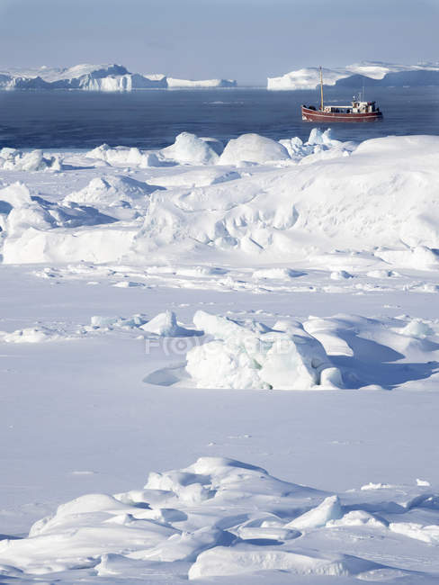 Лодка на замерзшей бухте Диско с айсбергами в Илулиссат Айсфьорд. Ледяной фьорд включен в список Всемирного наследия ЮНЕСКО. Америка, Северная Америка, Гренландия, Дания — стоковое фото