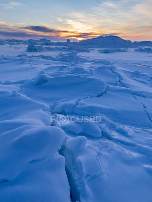 La orilla de la bahía congelada de Disko. Town Ilulissat at the shore of Disko Bay in West Greenland. El fiordo de hielo cercano está catalogado como patrimonio mundial de la UNESCO. América, América del Norte, Groenlandia, Dinamarca - foto de stock