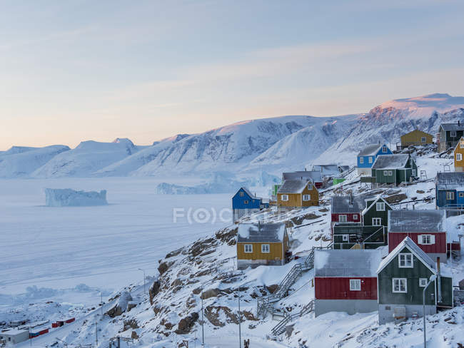 Ciudad Uummannaq durante el invierno en el norte de Groenlandia. Antecedentes: península de Nussuaq (Nugssuaq). América, América del Norte, Dinamarca, Groenlandia - foto de stock