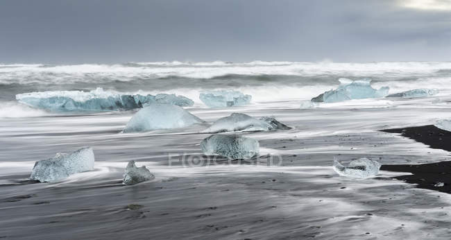 Icebergs na praia vulcânica preta. Praia do atlântico norte perto da lagoa glacial Joekulsarlon e geleira Breithamerkurjoekull no Vatnajoekull NP.europe, norte da europa, iceland, fevereiro — Fotografia de Stock