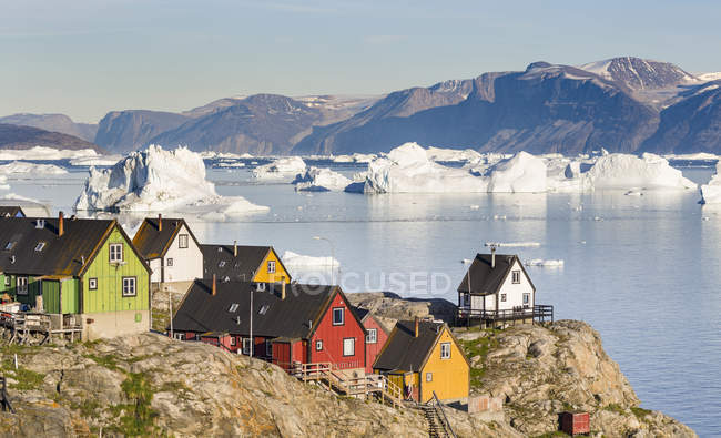 Місто Uummannaq на півночі Західної Гренландії, розташований на острові в системі Uummannaq фіорд, у фоновому режимі на півострові Нюссуак (Нугссуак). Америка, Північна Америка, Гренландія — стокове фото