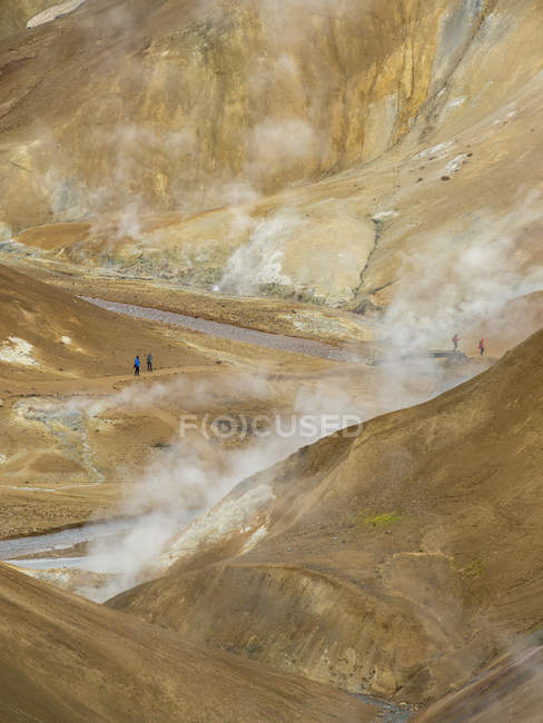Туристы в геотермальной зоне Гверадалир в горах Керлингарфьоэлл в высокогорье Исландии. Европа, Северная Европа, Исландия, Август — стоковое фото