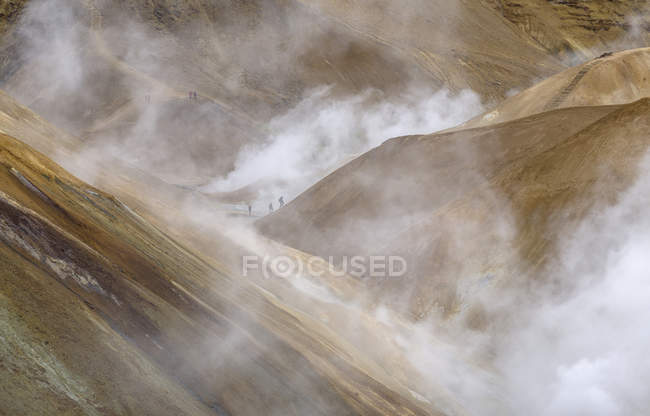 Senderistas en la zona geotérmica Hveradalir en las montañas Kerlingarfjoell en las tierras altas de Islandia. Europa, norte de Europa, Islandia, agosto - foto de stock