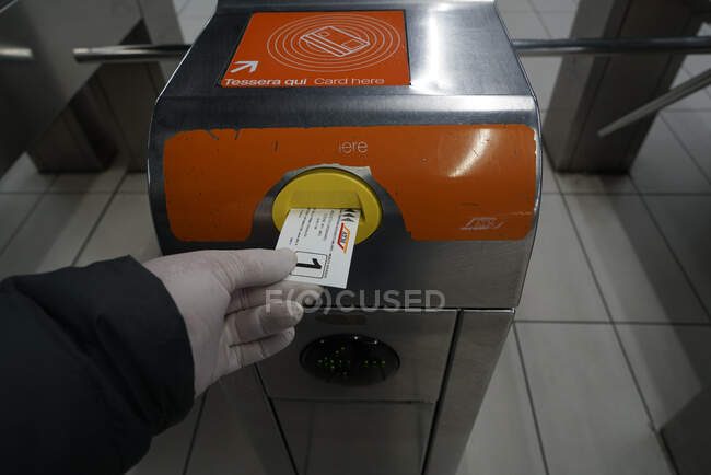 Человек держит билет на метро во время карантина коронавируса в Милане, образ жизни COVID-19, станция метро Duomo, Ломбардия, Италия, Европа — стоковое фото
