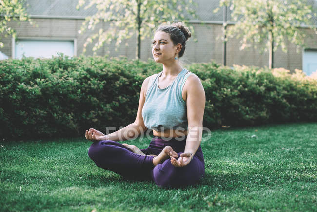 Méditation de yoga dans la pose de lotus dans le parc — Photo de stock