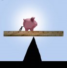 Person pushing piggy bank on ruler on top of peak — Stock Photo