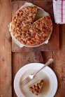 Домашний ореховый ореховый пирог с кленовым сиропом с кусочком на тарелке на деревянном столе — стоковое фото