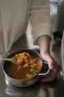 Жіночий шеф-кухарка, який перемішує веганське соєве рагу в сковороді . — стокове фото