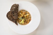 Kichererbsen-Gemüsesuppe mit Brotscheiben, von oben. — Stockfoto