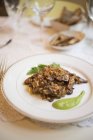 Коричневый рис с грибами, подаваемый с соусом на тарелке . — стоковое фото
