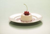 Panna cotta with cherry jam on vintage plate. — Stock Photo