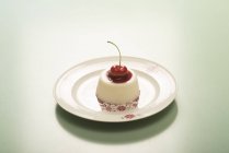 Panna cotta con confettura di ciliegie su piatto vintage . — Foto stock
