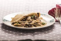 Lasagne mit Radicchio-Blättern auf Teller auf gepunkteter Tischdecke. — Stockfoto