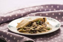 Lasagne con foglie di radicchio su piatto su tovaglia a pois . — Foto stock