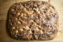 Vue du dessus de la pâtisserie de focaccia à grains entiers avec diverses graines sur table rustique . — Photo de stock