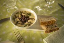 Горох и чечевичный сливочный суп в миске подается с ломтиками хлеба — стоковое фото