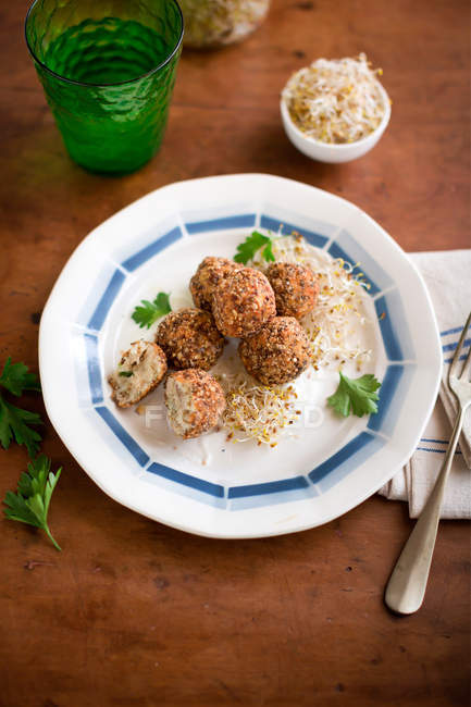 Baked mackerel meatballs with traditional labne cream cheese and sprouts on plate on wooden table — Stock Photo