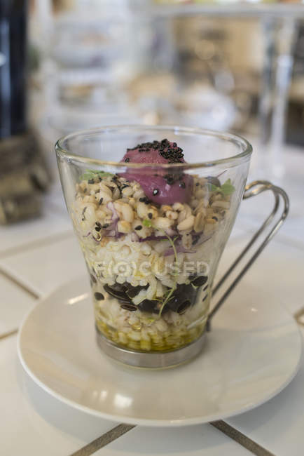 Glass of cereals and legumes in purple mayonnaise sauce. — Stock Photo