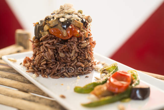 Красный рис с овощами на тарелке, крупным планом . — стоковое фото