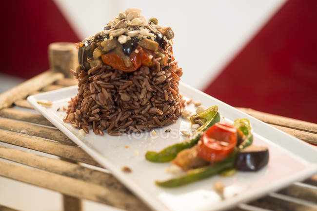 Roter Reis mit gegrilltem Gemüse auf Teller, Nahaufnahme. — Stockfoto