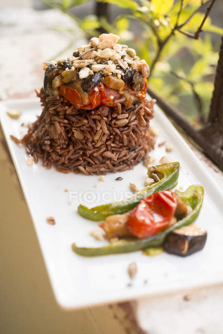 Червоний рис з овочами на тарілці, крупним планом . — стокове фото