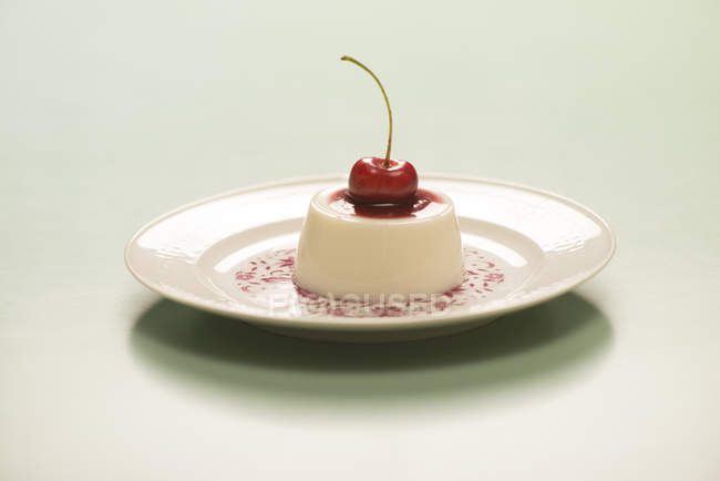 Panna cotta with cherry jam on vintage plate. — Stock Photo