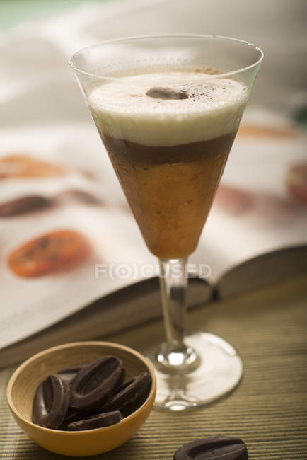Persimmon and chocolate mousse cream in drinking glass — Stock Photo