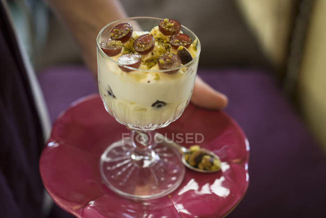 Crème de mascarpone aux raisins à la fraise et pistaches dans un verre à dessert . — Photo de stock