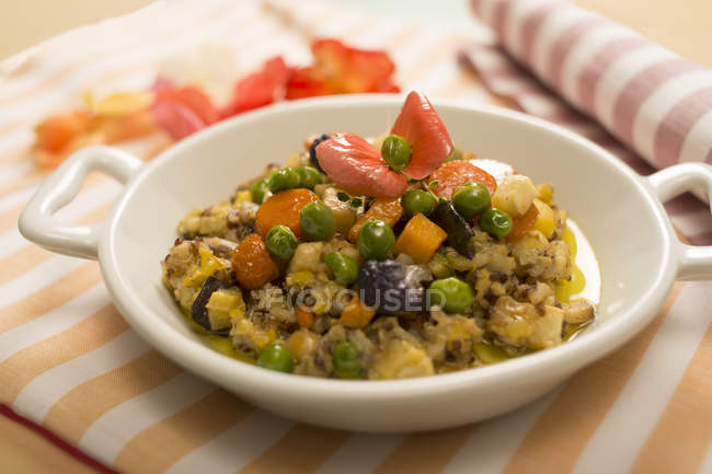Quinoa mit gedünstetem Gemüse im Teller auf dem Tisch. — Stockfoto