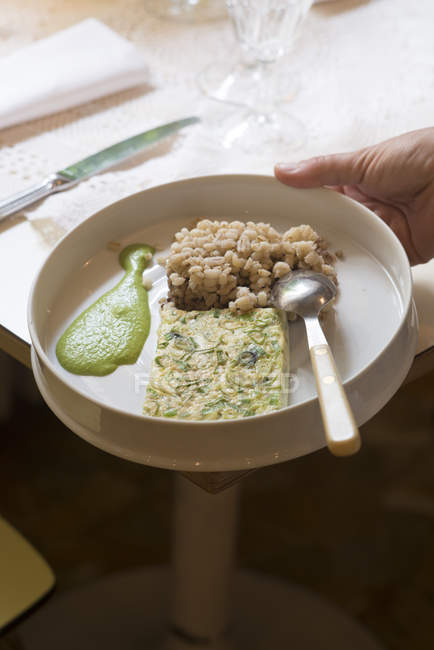 Gerste und Omelette mit Frühlingszwiebeln serviert mit Petersiliensauce. — Stockfoto