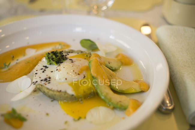 Avocado-Kartoffeltarte im Pecorino-Käse-Fondue mit Ei auf Teller. — Stockfoto
