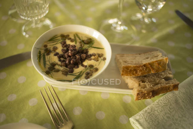 Chickpea and lentil cream soup in bowl served with bread slices — Stock Photo
