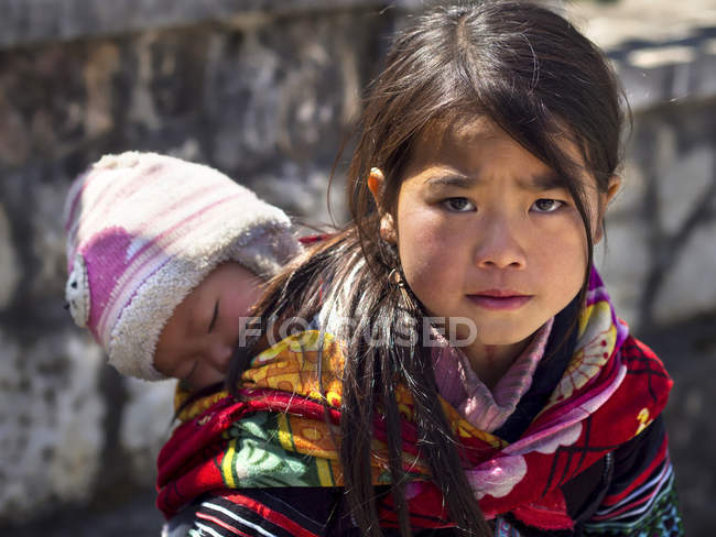 Hmong Mädchen trägt Baby in sapa Stadt, Vietnam — Stockfoto