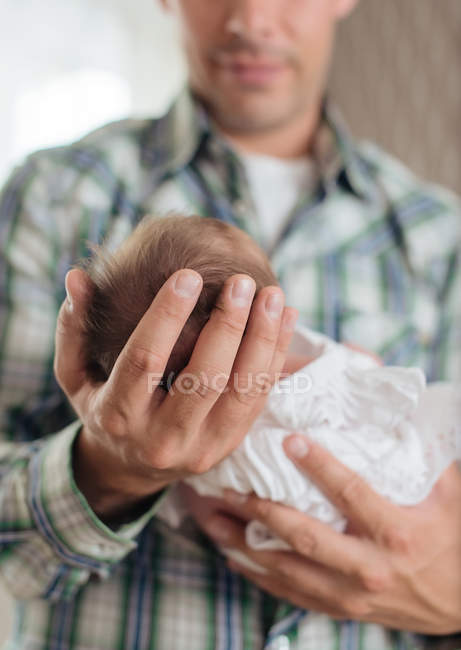 Nouveau-né avec une robe dans les bras de son père — Photo de stock
