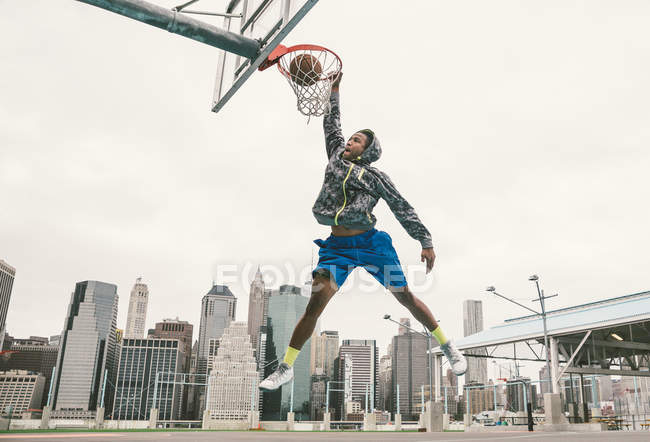 Jugador de baloncesto realizando slum dunk - foto de stock