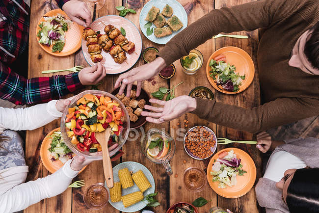 Pessoas jantando na mesa rústica — Fotografia de Stock