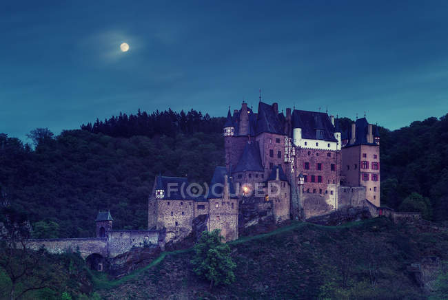 Old Brick Castle In Mountains At Night Sky With Full Moon