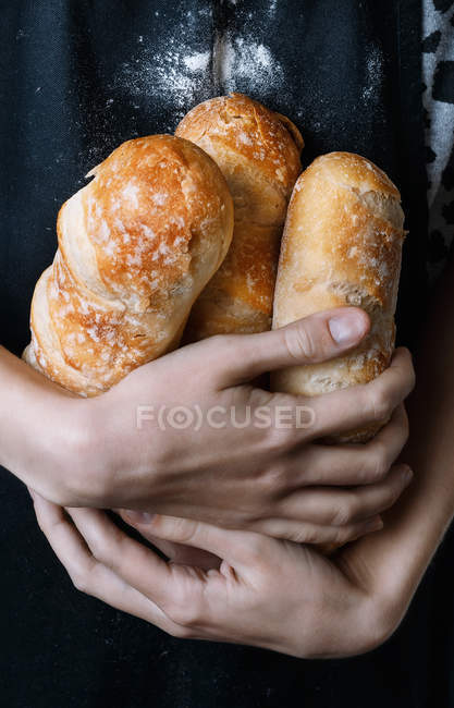 Female hands holding fresh baked bread — Stock Photo