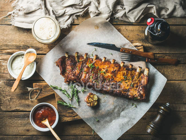 Roasted pork ribs with sauces, fried potato and dark beer — Stock Photo