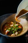 Крупним планом вигляд гастрономічного супу з інгредієнтами на столі — стокове фото