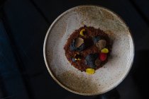 Schokoladentrüffel mit Nüssen und Beeren auf schwarzem Hintergrund — Stockfoto