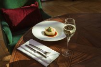 Vista de perto de delicioso prato branco com legumes e copo de vinho na mesa no restaurante — Fotografia de Stock