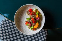 Vista dall'alto di delizioso pasto con verdure biologiche sul piatto rotondo sul tavolo — Foto stock