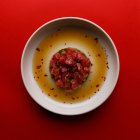 Blick von oben auf einen Teller mit Lachsscheiben auf Avocadopüree in einer Sauce — Stockfoto